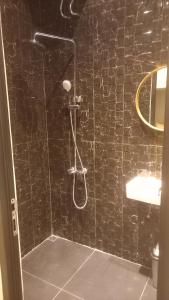 乌鲁瓦图Rumah WJ rooms and suites的带淋浴的浴室和黑色瓷砖墙