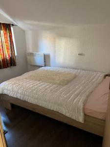 泰托沃Winterheim Sonnenberg的一间卧室配有一张带白色床罩的床