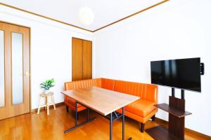 东京Maison Yachiyo 43m2 1 bedroom apartment的一间带桌子和电视的用餐室