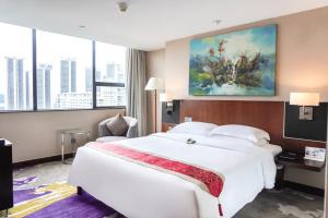 深圳深圳中洲圣廷苑酒店世纪楼, 华强北商圈的酒店客房带大型白色床和窗户。