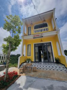 保禄Quê hương Villa (Indochine Villas Tam Chau)的黄色房子前面有桌子