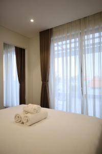胡志明市Cityhouse Villea的卧室配有带窗户的床上白色毛巾