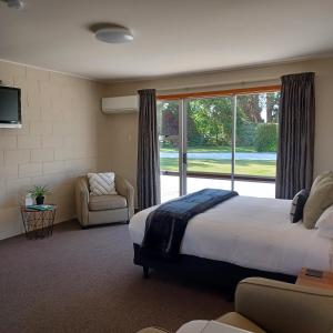 WardFlaxbourne Motels的一间卧室设有一张大床和一个大窗户