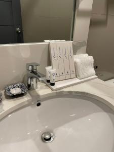 宿务Stacia Hotel powered by Cocotel的浴室水槽和镜子上的书籍
