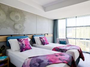 凯恩斯Crystalbrook Flynn的酒店客房设有两张床和窗户。