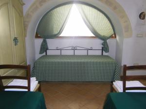 拉泰尔扎B&B Masseria Cappotto的一间卧室配有一张带窗户和两把椅子的床
