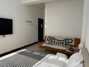 金宁乡且停民宿的一间卧室配有一张床、一张沙发和一台电视。