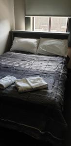 沃勒格尔Club Hotel Warragul的一张带两个枕头的床和一条毛巾