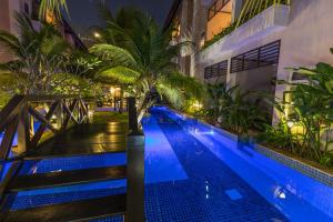金边巴厘酒店的一座游泳池,旁边是一座棕榈树