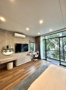 胡志明市Khánh Nguyễn Luxury Apartment, balcony street view, large bathtub的一间卧室配有一张床,墙上配有电视