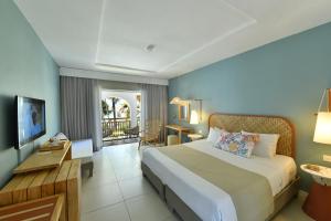 贝尔马尔Veranda Palmar Beach Hotel & Spa - All Inclusive的酒店客房设有一张大床和一个阳台。