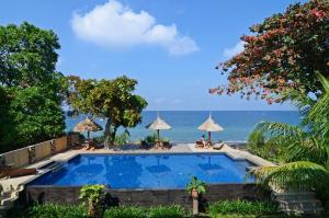 圣吉吉龙目岛日落酒店的一座背景海洋的游泳池