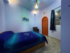 舍夫沙万Dar Fatima的一间卧室配有蓝色的床和椅子