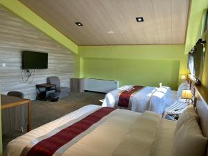 埔里埔里夏都華蔓山林日式會館 Puli Huaman Villa的酒店客房设有两张床和一台平面电视。