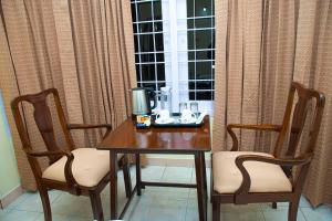 乌提Priyadeep BnB的一张带两把椅子的木桌和窗户