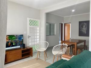 马里利亚Linda Casa com Piscina的客厅配有沙发、椅子和电视