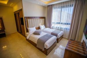 瓦迪穆萨Petra Icon Hotel的一间卧室设有两张床和大窗户