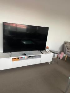 悉尼Ocean view 2 Bedroom apartment的白色娱乐中心的大型平面电视