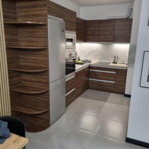 托伦Komfortowy apartament的厨房配有木制橱柜和冰箱。