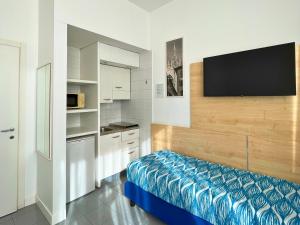 米兰Navigli Suites的墙上配有电视的小厨房