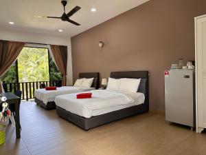 丹绒鲁Red Coral Cottage的一间带两张床的卧室和一个阳台