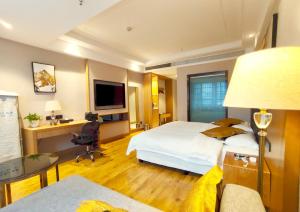 张家界Zhangjiajie ViVi Boutique Hotel的酒店客房设有一张大床和一张书桌。