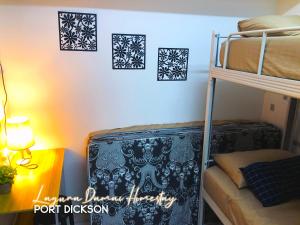 波德申Laguna Damai Homestay Teluk Kemang PD 3BR- Pool View的客房配有一张双层床和一张带台灯的书桌。