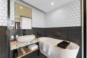 上海上海宓亚酒店(徐家汇交大店)的带浴缸、水槽和镜子的浴室