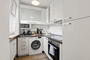 奥格斯堡ma suite - modern apartment 2P central Augsburg的厨房配有白色橱柜、洗衣机和烘干机
