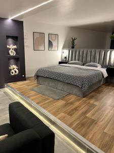 GargenvilleAzulik Spa & Jacuzzi privatif的一间卧室设有一张大床,铺有木地板。