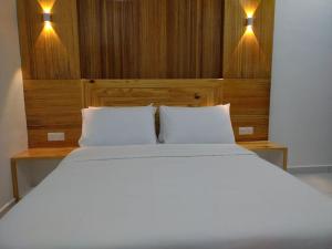 珍南海滩FUNDUQ AL BUSYRA的一张带两个白色枕头的床