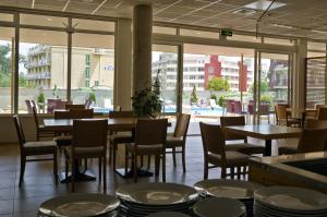 克兰内沃美景酒店的餐厅设有桌椅,享有游泳池的景色
