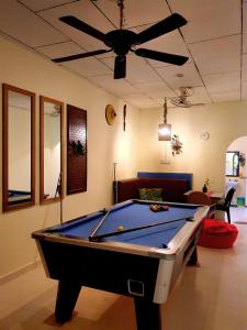 珍南海滩THE COTTAGE LANGKAWI的客厅配有一张台球桌和吊扇