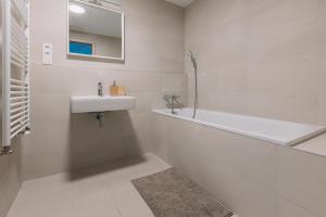 布拉迪斯拉发SKAU Coral Residence in Sky Park 22 floor 1Tower Panoramic View Free Parking的白色的浴室设有水槽和浴缸。
