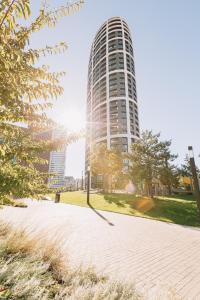 布拉迪斯拉发SKAU Coral Residence in Sky Park 22 floor 1Tower Panoramic View Free Parking的一座高大的建筑,前面有阳光