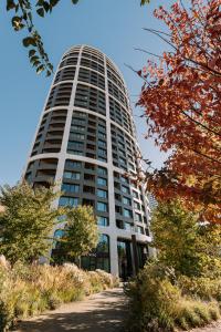布拉迪斯拉发SKAU Blue Residence in Sky Park 21 floor 2 tower Panoramic View Free Parking的一座高大的白色建筑,前面有树木