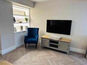 基督城Brand New Riverside Apartment的客厅配有蓝色椅子和平面电视