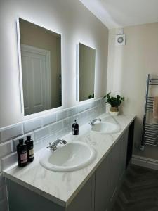 基督城Brand New Riverside Apartment的浴室设有2个水槽和2面镜子