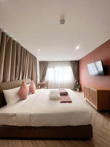 邦拉SO Zen Hotel Silom Bangkok的卧室配有白色大床和粉红色的墙壁