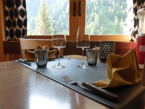 格里门茨Hôtel Cristal - Swiss Riders Lodge Grimentz的酒杯桌子和餐巾