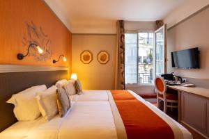 巴黎富驰酒店的配有一张床和一张书桌的酒店客房