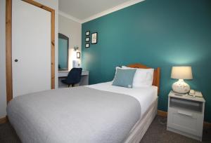 CarinishTemple View Hotel的一间卧室设有一张床和蓝色的墙壁