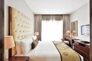浦那普纳万豪套房酒店的酒店客房设有一张大床和一张书桌。