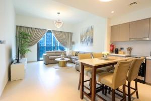 迪拜HiGuests - Beautiful 2BR on 35th floor With Amazing City View的厨房以及带桌子和沙发的客厅。