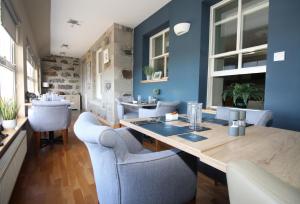 CarinishTemple View Hotel的一间拥有蓝色墙壁和一张木桌及椅子的用餐室