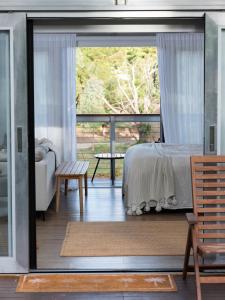 MaranangaThe Villas - Barossa的一间卧室设有一张床和一个滑动玻璃门