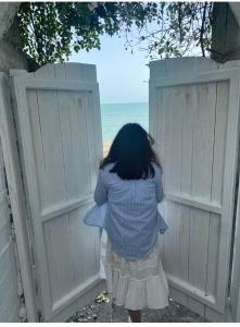 新阿丰阿丰别墅的看着海洋围栏的年轻女孩