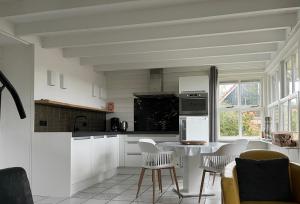 OudesluisZijper Eilant House的厨房配有白色橱柜和桌椅