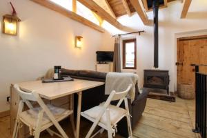 Saint-MarcelCharmante maison de hameau traditionnel montagnard的客房设有桌椅和壁炉。