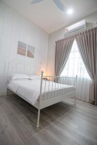 马兰Romi Homestay Wakaf Tapai的卧室配有白色的床和窗户。